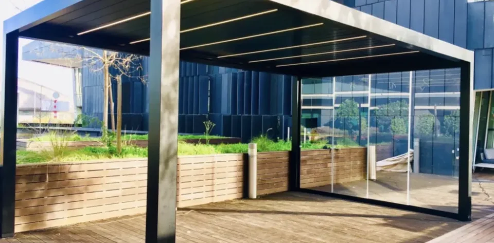 Grey frame bioclimatic pergola with glass sliding doors and LED strip lighting